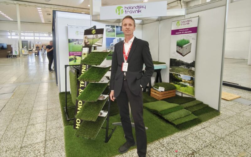 Zástupca Holandského trávnika stojí v stánku na výstave Agrokomplex s ukážkami umelého trávnika